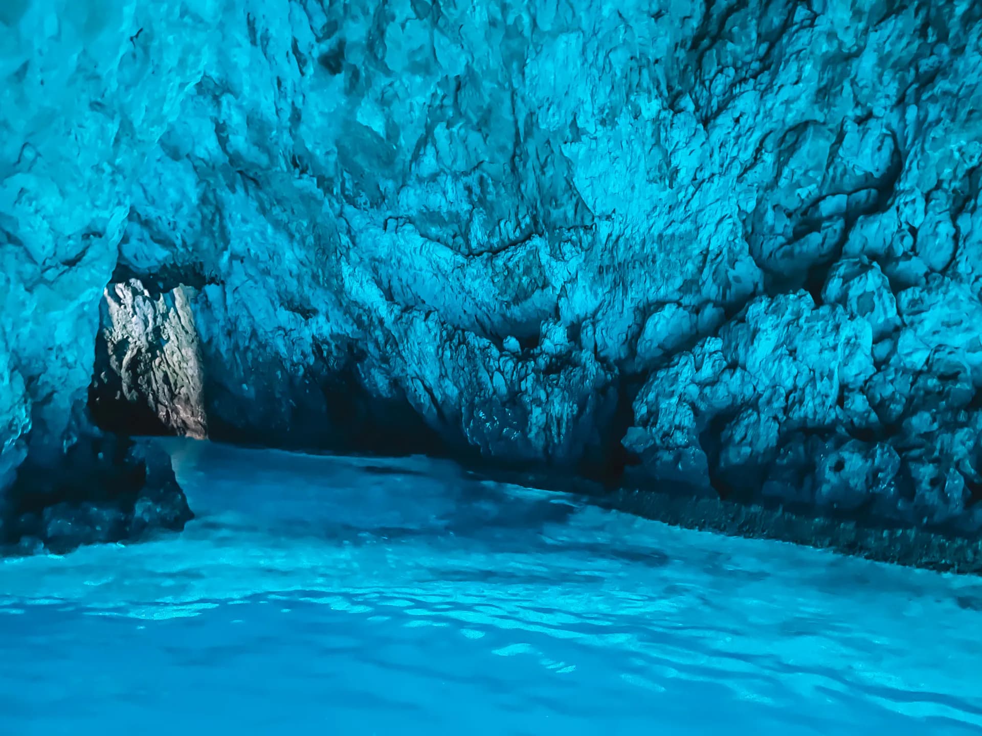 Inside the Blue Cave on Biševo — the chamber lit electric aquamarine by sunlight refracting through the underwater entrance — Blue Cave & 5 Island Tour