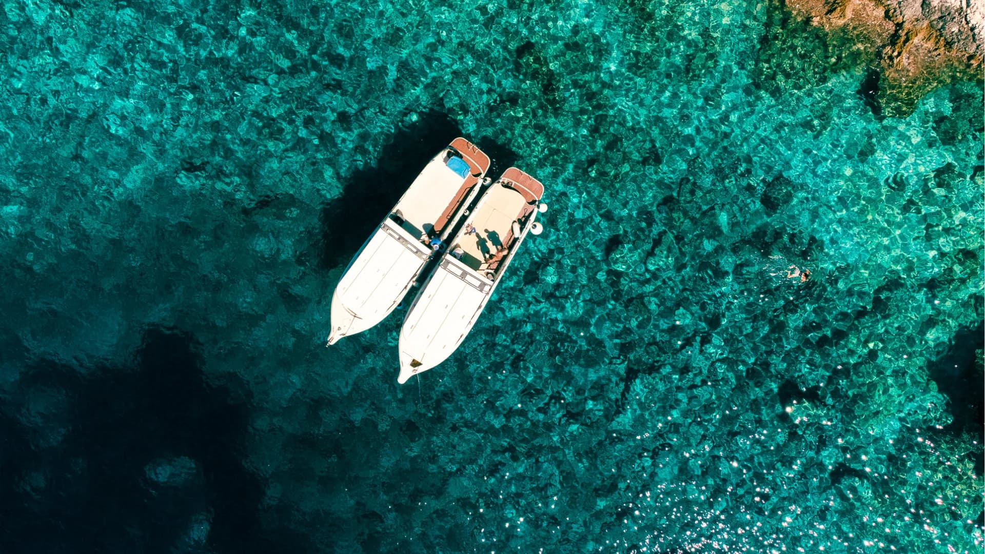 Two speedboats rafted over a turquoise reef, a swimmer in the water alongside — Blue Cave & 5 Islands — Private