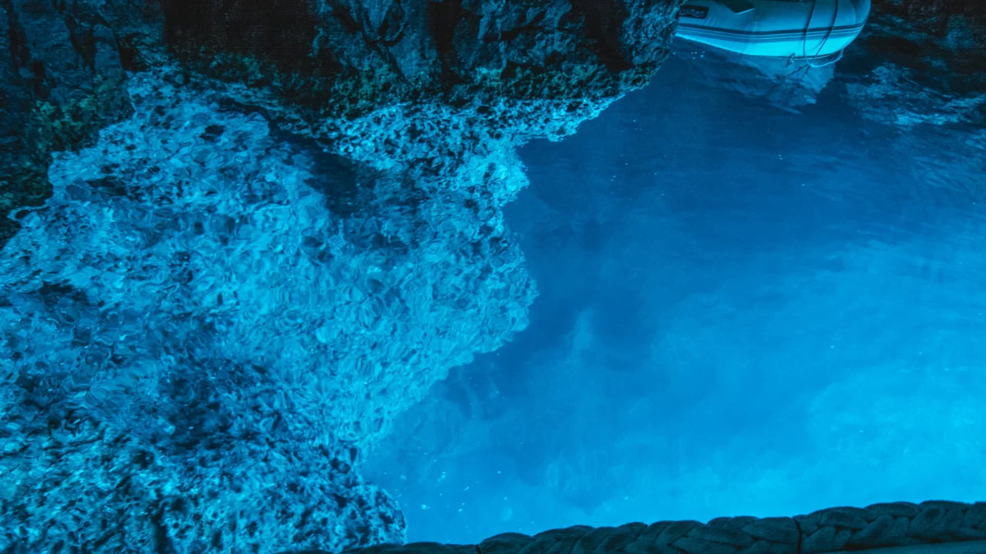 The glowing water surface inside the Blue Cave, seen from a boat waiting its turn — Blue Cave & 5 Islands — Private