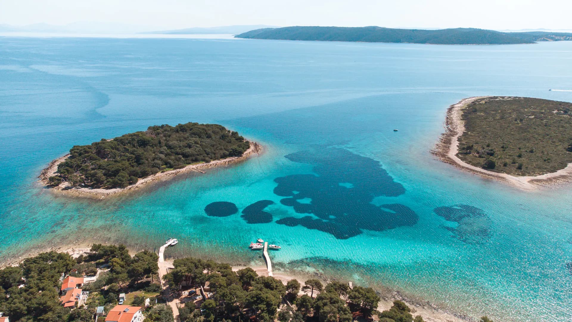 The Blue Lagoon from the air, two wooded islets and the shallow channel between them. Blue Lagoon & Trogir: Private Half Day