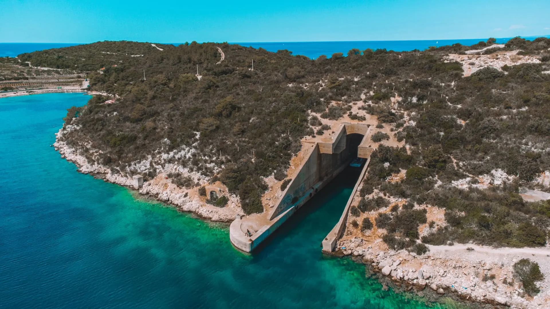 The entrance to the submarine tunnel cut into the cliff on Brač, seen from the air. Brač, Hvar, Pakleni & Šolta Private Tour
