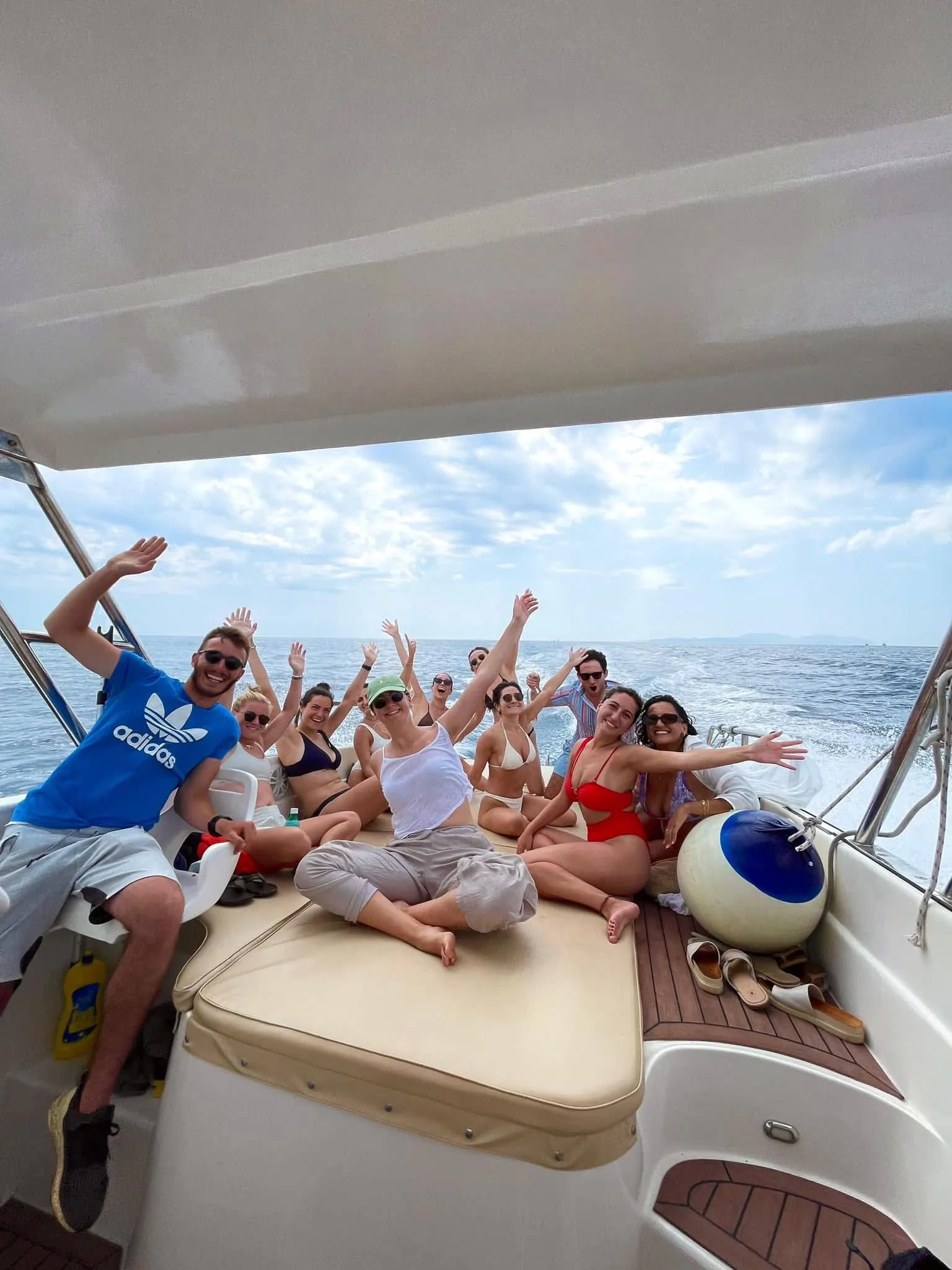 Guests on the bow of the boat with their arms up on the way back to Split — Blue Cave Tours